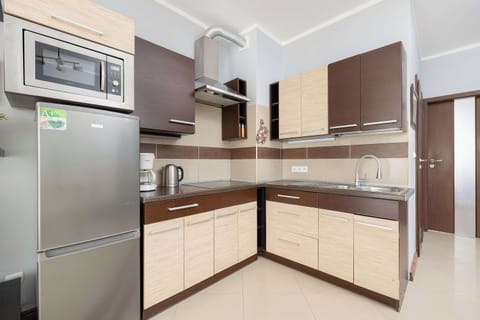 A fully equipped kitchen with sleek wooden cabinets, modern appliances, and ample counter space. Ideal for preparing delicious meals during your stay.