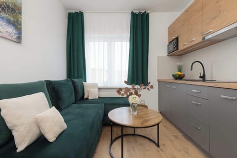 Living room with a comfortable corner sofa bed and kitchenette.