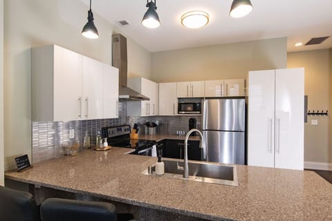 A fully-equipped kitchen featuring high-end finishes and bar seating—everything you need to prep, cook, and refuel