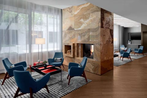 Lobby seating around a stone fireplace with blue chairs and rugs