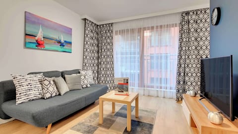 A modern and cozy living area featuring a niebieską sofa and tasteful wall art.