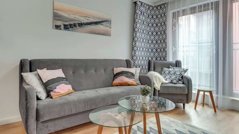 A modern and cozy living area featuring a gray sofa, yellow accents, and tasteful wall art.
