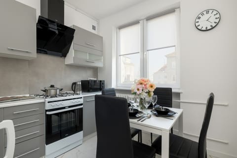 Fully equipped kitchen with gas stove and dining area.