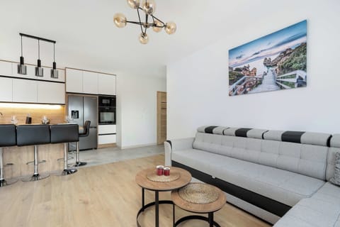 Another view of the L-shaped sofa in the living room, emphasizing its comfort and contemporary design. The bright and airy atmosphere enhances the welcoming feel of the space.