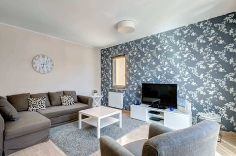 The living room features a sofa bed, coffee table and a flat-screen television, providing entertainment during relaxation.