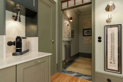 Another angle of the kitchen area with a coffee machine, kettle, and subway-tiled backsplash.