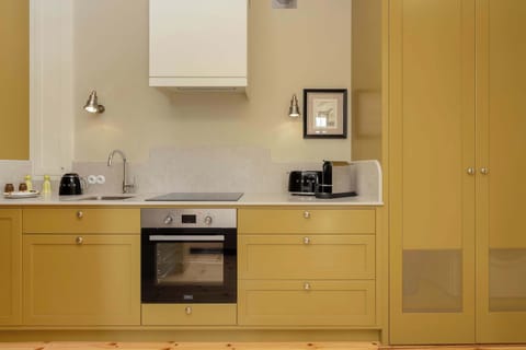 A close-up of a small but functional kitchen, with white countertops and modern appliances.