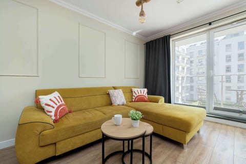 Tastefully decorated living room with a corner sofa bed, coffee table and access to balcony.