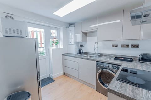 Bright kitchen with oven, fridge, kettle and microwave