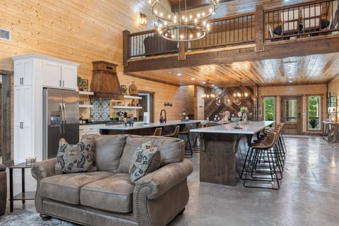 From morning pancakes to midnight snacks, this dreamy kitchen and island space is perfect for gathering, grazing, and making memories under those glowing chandeliers.