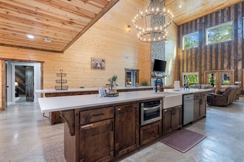 Rustic meets modern in this open-concept kitchen—plenty of prep space, farmhouse sink, and glowing views into the great room make it the heart of the cabin.