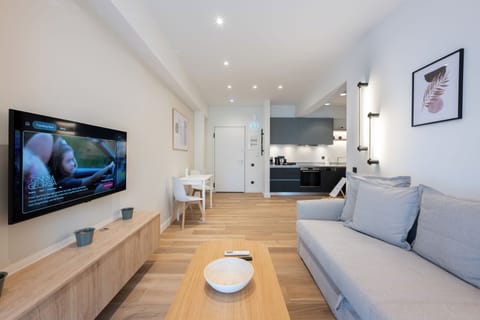 Bright, modern living space with cosy seating and a sleek open-plan kitchen.