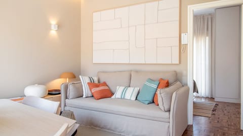 Soft neutrals meet pops of color in this cozy living room — perfect for relaxing after a stroll along the beach. #FozDoDouroLiving #CoastalStyle