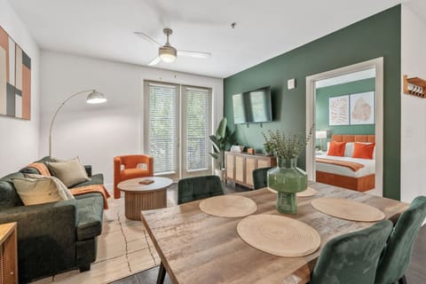 Open-concept living and dining space with stylish decor, Smart TV, and natural light