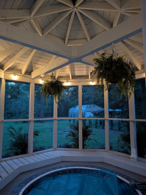 Enjoy the large, in-ground, screened-in hot tub w/ string lights to the set mood