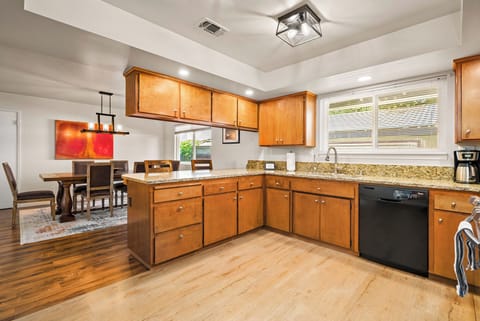 This wide concept space ensures a perfect flow between the kitchen and dining area. Enjoy the inviting atmosphere of the wood cabinetry and granite counters. The breakfast bar and dining area, with the modern art, offer multiple comfortable gathering spots
