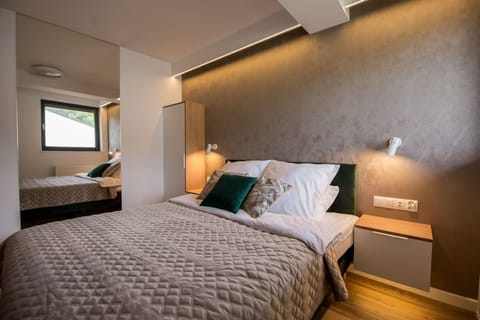 Cozy bedroom with double bed, soft lighting, and modern wallpaper.