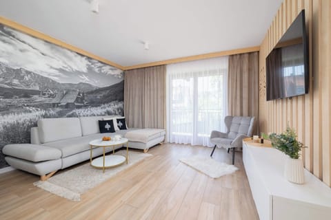 Seating and TV corner – Comfortable spot for relaxation with wall-mounted TV and natural lighting.