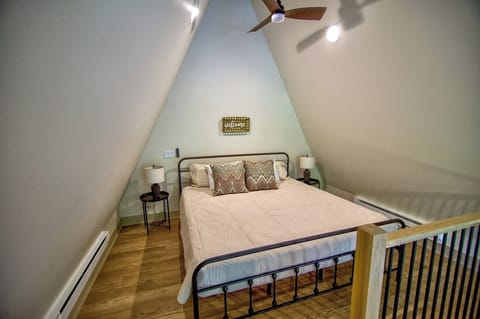 Unwind in the cozy loft bedroom under soaring A-frame ceilings.