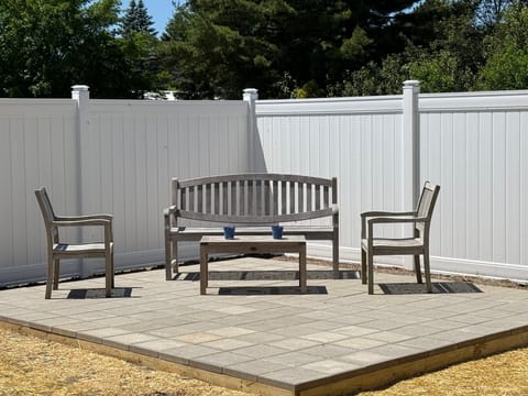 Private backyard oasis with teak furnishings and a brand-new fenced patio.