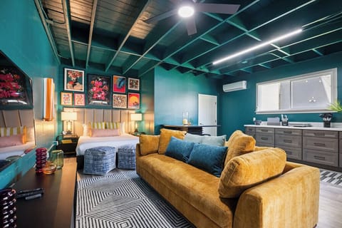 Bold, modern, and full of personality—this vibrant studio features a plush king bed, stylish decor, a luxe velvet sofa, and a sleek kitchenette. Perfect for a chic stay with comfort and flair!
