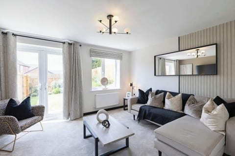 “Relax in our stylish living room featuring a cozy corner sofa, Smart TV for your favorite streaming apps, and beautiful views through large patio doors. A perfect space to unwind, whether enjoying a movie night or soaking in the natural light.”