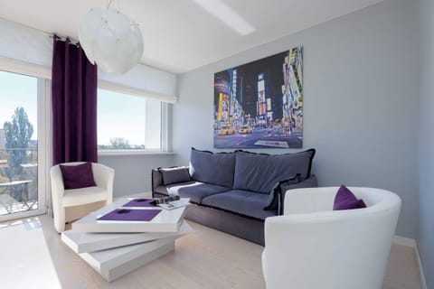 Modern bedroom with a comfortable sofa for two people, a coffee table and access to the balcony.