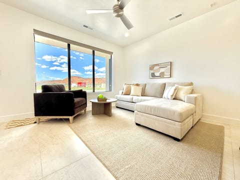 Floor-to-ceiling windows fill this modern living room with sunshine and frame breathtaking red rock vistas!