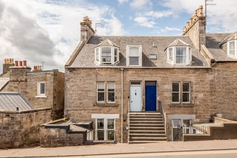 Traditional stone building with bay windows and blue doors