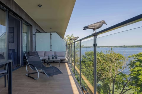 The balcony with a comfortable seating set and a view of the surroundings invites outdoor relaxation.