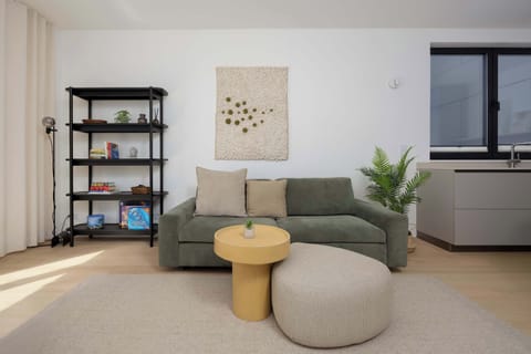 Bright and spacious living room with a comfortable green sofa.