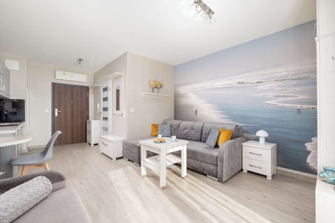 Another view of the living room area, emphasizing its bright, modern look. The gray sofa and matching furniture create a cohesive, stylish look.