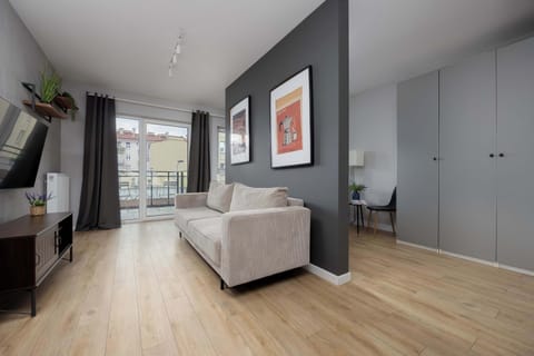A modern flat space where a living and bedroom area has been separated with a comfortable relaxation area.