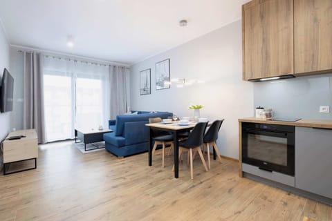 The living area features a sleek coffee table and a flat-screen television.