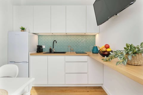 The white, modern fully decorated kitchen is conducive to preparing delicious meals.