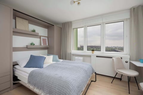 The studio features a cozy relaxation area with large windows that let in plenty of natural light.