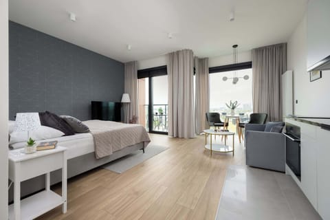 The living space with large windows seamlessly blends lounging and cooking areas for everyday comfort.