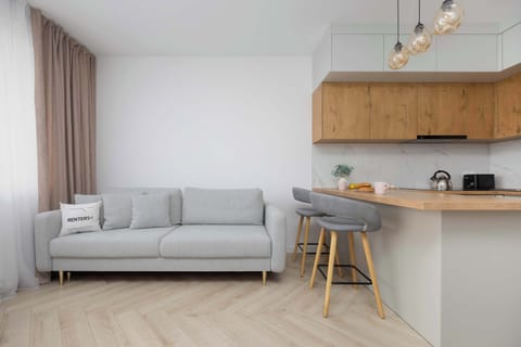 A corner sofa and bar area provide a cozy spot for relaxing and quick meals.