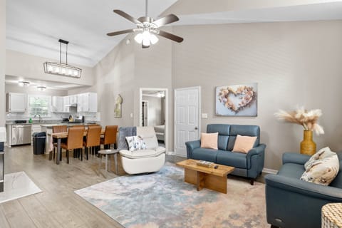 Bright and inviting open-concept living space featuring cozy seating, a modern kitchen with stainless steel appliances, and a spacious dining area...perfect for relaxing or entertaining.