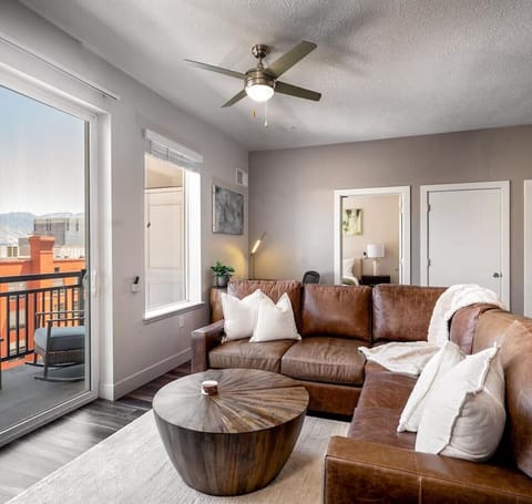 Beautifully designed living room. 75` TV, leather sofa and amazing views of mountains and city skyline.