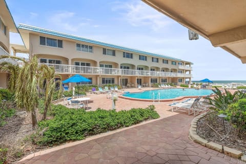 Relax at this beachfront getaway featuring a sparkling resort pool, sun loungers, tropical landscaping, and easy beach access. Perfect for a coastal vacation stay with beautiful Gulf views and resort-style amenities.
