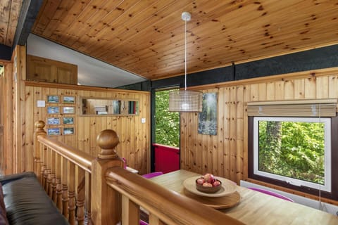 Small bannister overlooking the dining area, window and timber walls