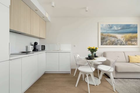 A sleek, fully equipped kitchen with light cabinetry and a clean, minimalist design. Ideal for cooking at home during your stay.