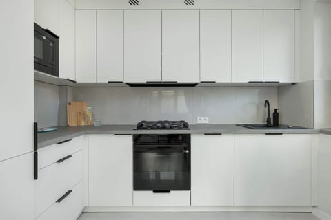 Fully equipped white kitchen with all essential appliances – A clean, functional space for cooking.