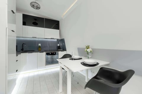 Compact kitchenette with a dining table and modern chairs, perfect for quick meals.