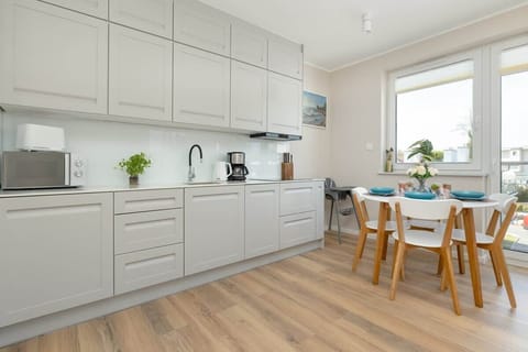 Fully equipped kitchenette with kitchen appliances and dining area.