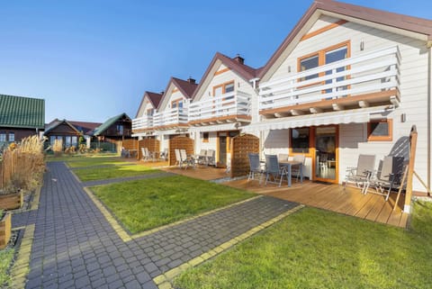 View of wooden holiday cottages with balcony and access to the garden.