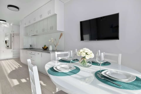 The modern dining area with white cabinetry and a decorative table sets the scene for stylish gatherings.