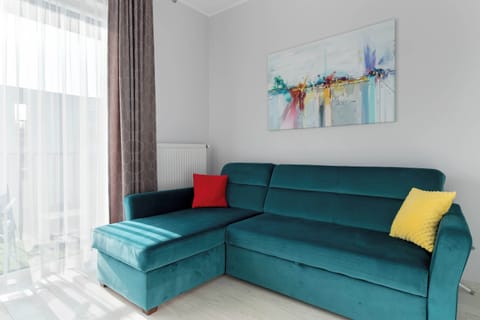 The vibrant turquoise sofa with colorful cushions adds a cheerful touch and invites you to unwind after a long day.