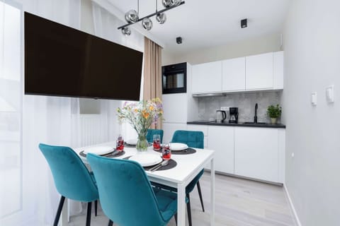 TV, dining area and kitchenette well-equipped with modern appliances.